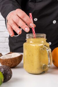 front-view-chef-putting-straw-fruit-juice