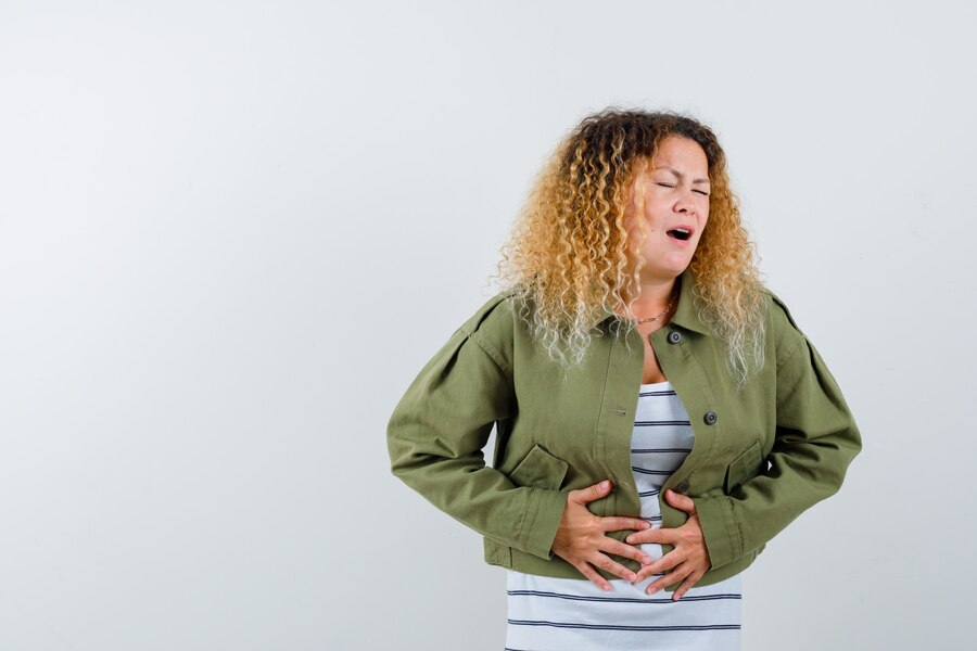 mature-woman-suffering-from-stomach-pain-green-jacket-t-shirt-looking-painful